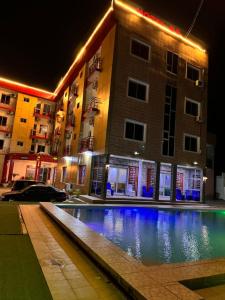 a swimming pool in front of a building at night at SEGMAD HOTEL in Kribi