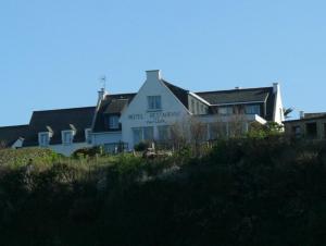 a large white house on top of a hill at Hôtel-Restaurant des Iles in Houat
