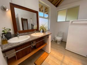 a bathroom with two sinks and a mirror at Casa Cosmonova in Puerto López