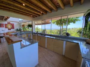 a large kitchen with a large counter and a large window at Casa Cosmonova in Puerto López