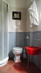 La salle de bains est pourvue de toilettes et d'une table rouge. dans l'établissement Agriturismo Il Cucco, à Altedo