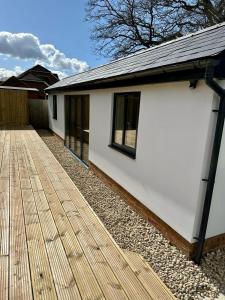a white house with a wooden deck at White Oaks Sussex in Twineham +15 photos