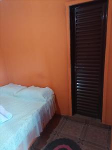 - une chambre avec un mur orange, un lit et une fenêtre dans l'établissement Pousada Pôr do Sol, à Uberlândia