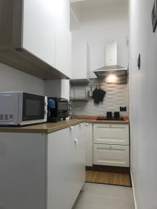 a kitchen with white cabinets and a microwave at Ribera villa alloggio 2 in Ribera