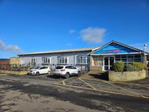 two cars parked in a parking lot in front of a building at Stacey's Homely Haven in Cresswell