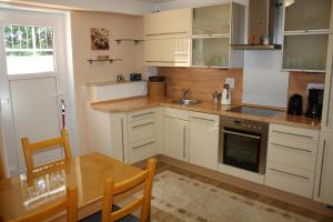 a kitchen with white cabinets and a table and a sink at Ferienwohnung Alona in Garz