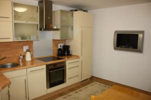 a kitchen with white cabinets and a sink at Ferienwohnung Alona in Garz +5 photos