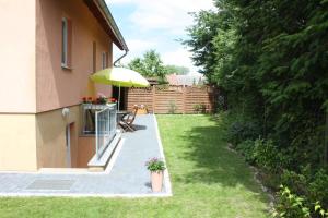 a patio with a bench and an umbrella in a yard at Ferienwohnung Alona in Garz