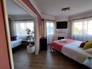 une chambre avec un lit, un canapé et des fenêtres dans l'établissement Hostal Casa Lhotse, à Viña del Mar