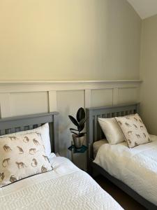 two beds sitting next to each other in a bedroom at White Oaks Sussex in Twineham