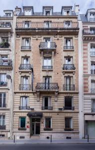 - un grand bâtiment en briques avec des balcons dans une rue dans l'établissement Parc Hotel, à Paris