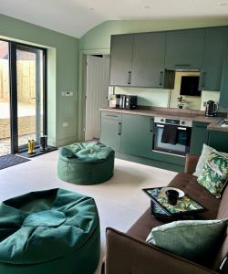 a living room with two couches and a kitchen at White Oaks Sussex in Twineham
