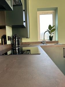 a kitchen counter with a sink and a window at White Oaks Sussex in Twineham
