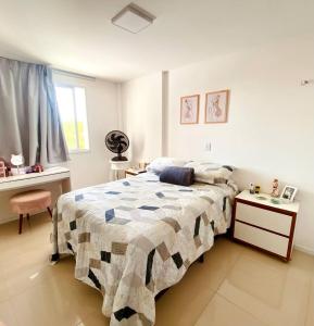 a bedroom with a bed and a table and a window at Apartamento Charme Benfica in Fortaleza