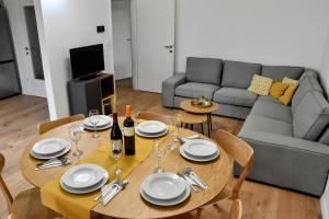 a table with plates and wine glasses and a couch at Vacation home Pula in Pula