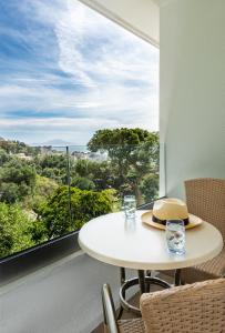 einen weißen Tisch und Stühle in einem Zimmer mit einem großen Fenster in der Unterkunft Rock Hotel in Gibraltar