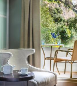 a room with a chair and a table and a window at Rock Hotel in Gibraltar