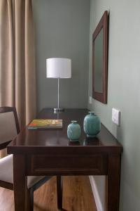 a wooden table with two vases on top of it at Rock Hotel in Gibraltar