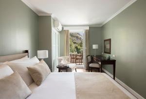 a bedroom with a bed and a desk and a chair at Rock Hotel in Gibraltar