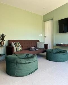 a living room with a couch and two green ottoman at White Oaks Sussex in Twineham