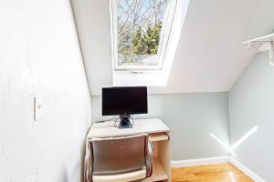 a computer on a desk in a room with a window at Woods Hole Hideaway in Falmouth
