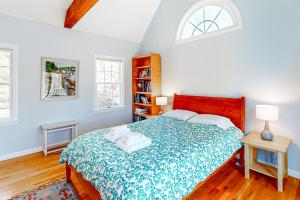 a bedroom with a bed with a green and white blanket at Woods Hole Hideaway in Falmouth