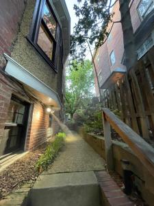 un callejón entre un edificio de ladrillo y una casa en 2 Bedroom by Zoo, Metro, Park and Embassies in Forest Hills - Best Location, en Washington