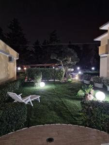 a backyard at night with a bench in the grass at casale in Brindisi