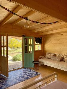カンディアにあるEudaimonia Wooden Suites Nafplio Kandiaの木造キャビンのポーチ(ベッド1台、ドア付)