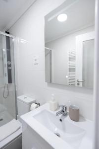 a white bathroom with a sink and a mirror at Cozy Bohemian Duplex-Lemon in Lisbon