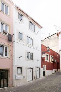 a white building with windows on the side of a street at Cozy Bohemian Duplex-Lemon in Lisbon