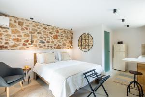 um quarto com uma cama e uma parede de pedra em Kifissia Studio em Atenas