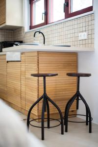 a kitchen with two stools in front of a counter at Kifissia Studio in Athens