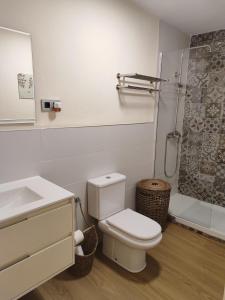 a white bathroom with a toilet and a shower at Casa Pepa in Corcubión