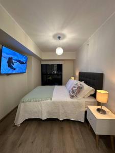 a bedroom with a bed and a tv on the wall at San Isidro Estreno Luxury Apart Pool Gym 804SI in Lima +20 photos