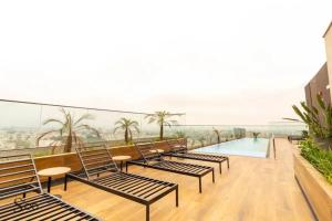a balcony with chairs and a swimming pool on a building at San Isidro Estreno Luxury Apart Pool Gym 804SI in Lima