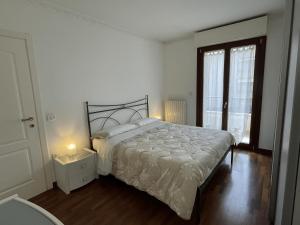 a white bedroom with a bed and a window at Casa Giorgio in Fano