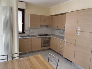 a kitchen with wooden cabinets and a table with chairs at Casa Giorgio in Fano