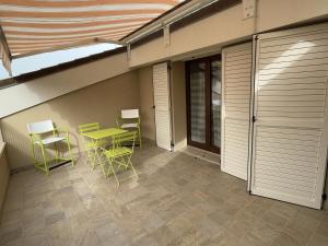 a patio with a green table and chairs on it at Casa Giorgio in Fano