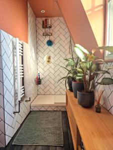 ein Bad mit einer Dusche mit Topfpflanzen in der Unterkunft Charming bedroom in artist studio in London