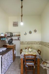 a kitchen with a table and chairs in a room at Filuvespri in Comiso