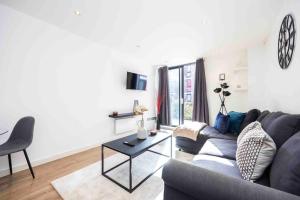 a living room with a couch and a table at Stylish 1 BR Apartment Near Shoreditch - 10 Min Walk in London