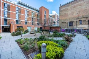 a garden in front of a brick building at Stylish 1 BR Apartment Near Shoreditch - 10 Min Walk in London