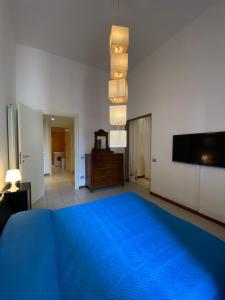 a bedroom with a blue bed and a flat screen tv at Appartamento Al Teatro in Livorno