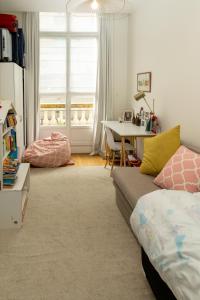 a living room with a bed and a table with a desk at Appartement sur les quais in Paris