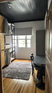 a room with a desk and a table and a rug at Hostel Hug Brasil in Curitiba