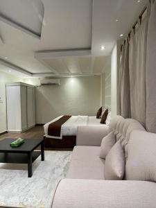 una camera d'albergo con divano e letto di شاليهات ليالينا a Muhayil