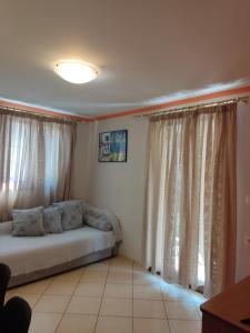 um quarto com uma cama e uma janela com cortinas em Villa Alexandros em Parga