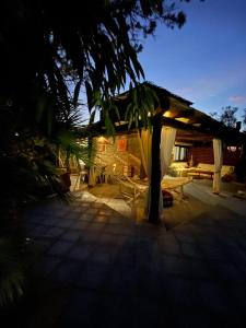 un patio con un padiglione con un tavolo e un albero di La Villa Del Paradiso a Stintino