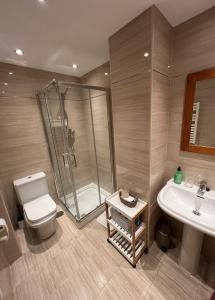 Un baño con ducha, inodoro y lavabo. en sands apartments, en Ribadesella
